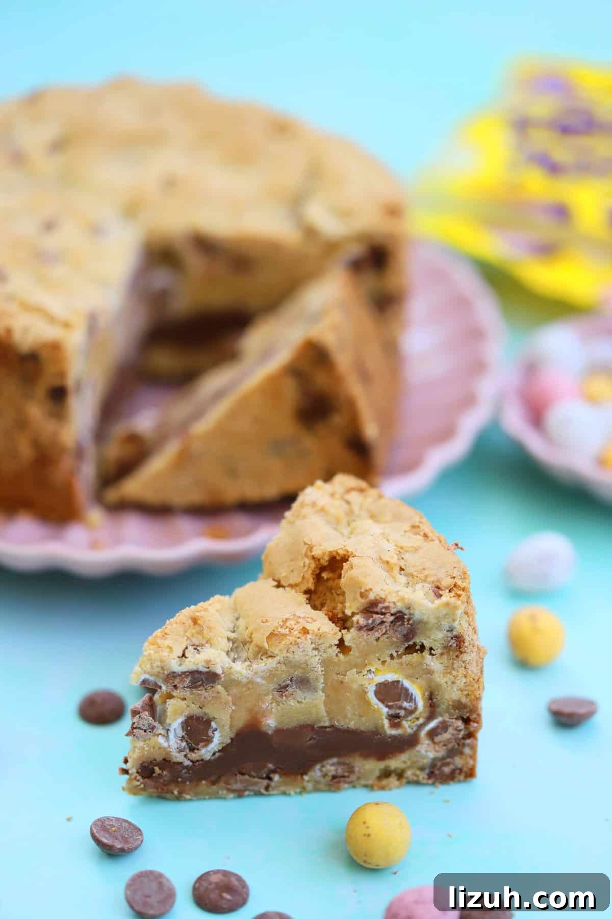 Mini Egg Cookie Pie Recipe: Creamy No-Bake Easter Dessert 3 A Mini Egg Cookie Pie with a wedge taken out of it, on a pink plate.