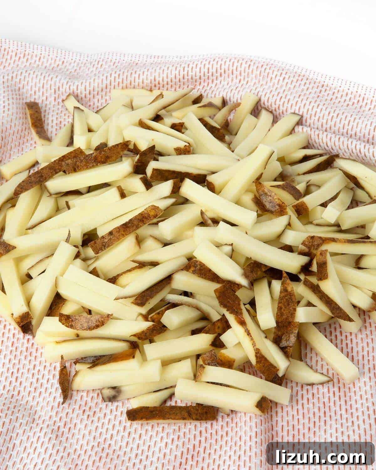 Crispy Air Fryer French Fries: Perfect Golden Recipe 8 cut potatoes drying on kitchen towel