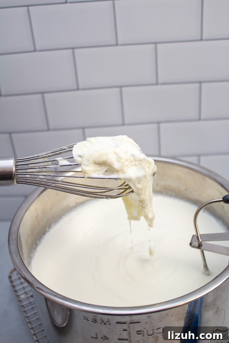 How to Make Creamy Instant Pot Yogurt at Home 13 Removing the milk skin from the surface of an Instant Pot insert with a whisk.