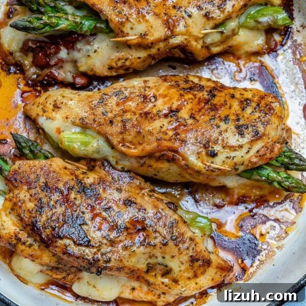 Crispy Parmesan-Roasted Asparagus — Oven-Baked Recipe 7 chicken breast stuffed with asparagus and cheese on a pan.