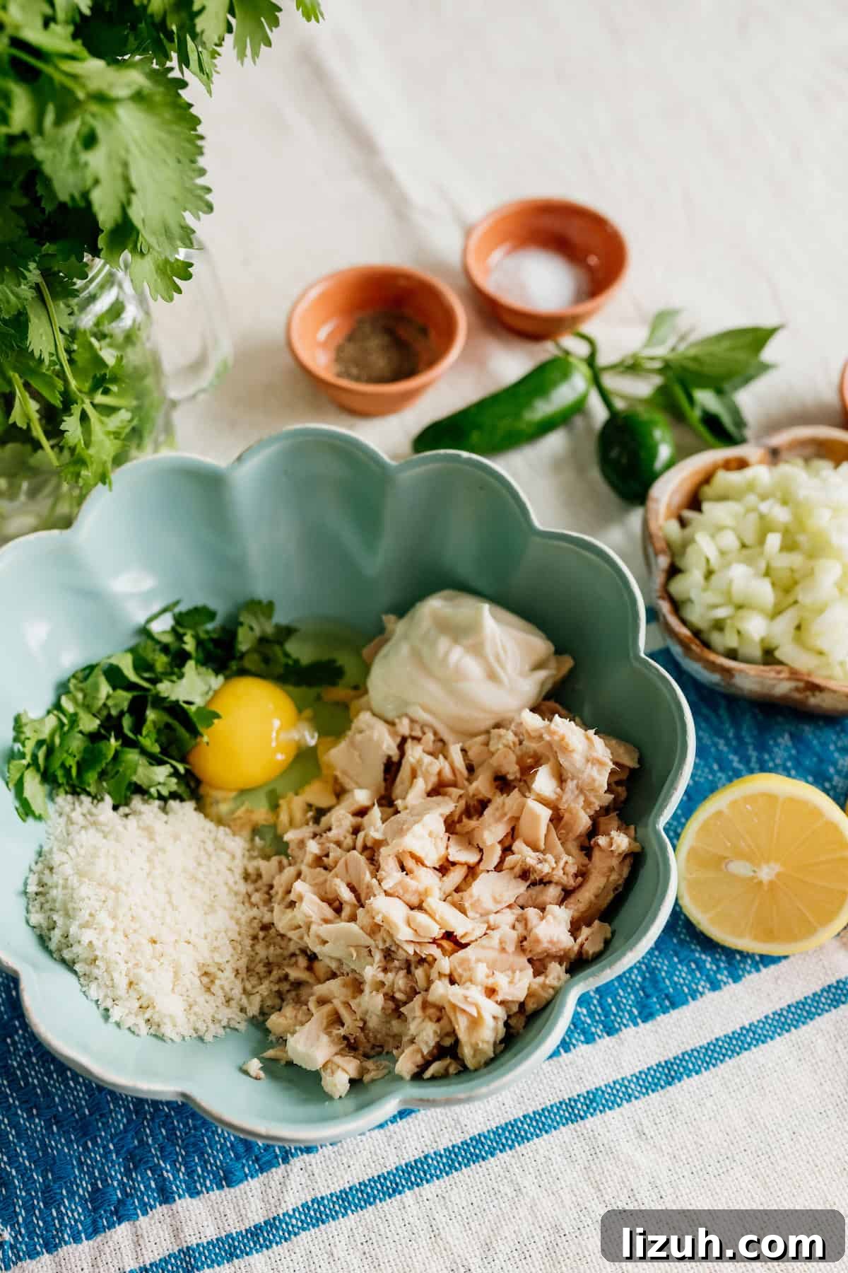 Crispy Tuna Patties with Lemon-Dill Sauce 3 ingredients to make tuna patties - tuna, Panko, mayonnaise, eggs, cilantro, celery and lemon in a bowl