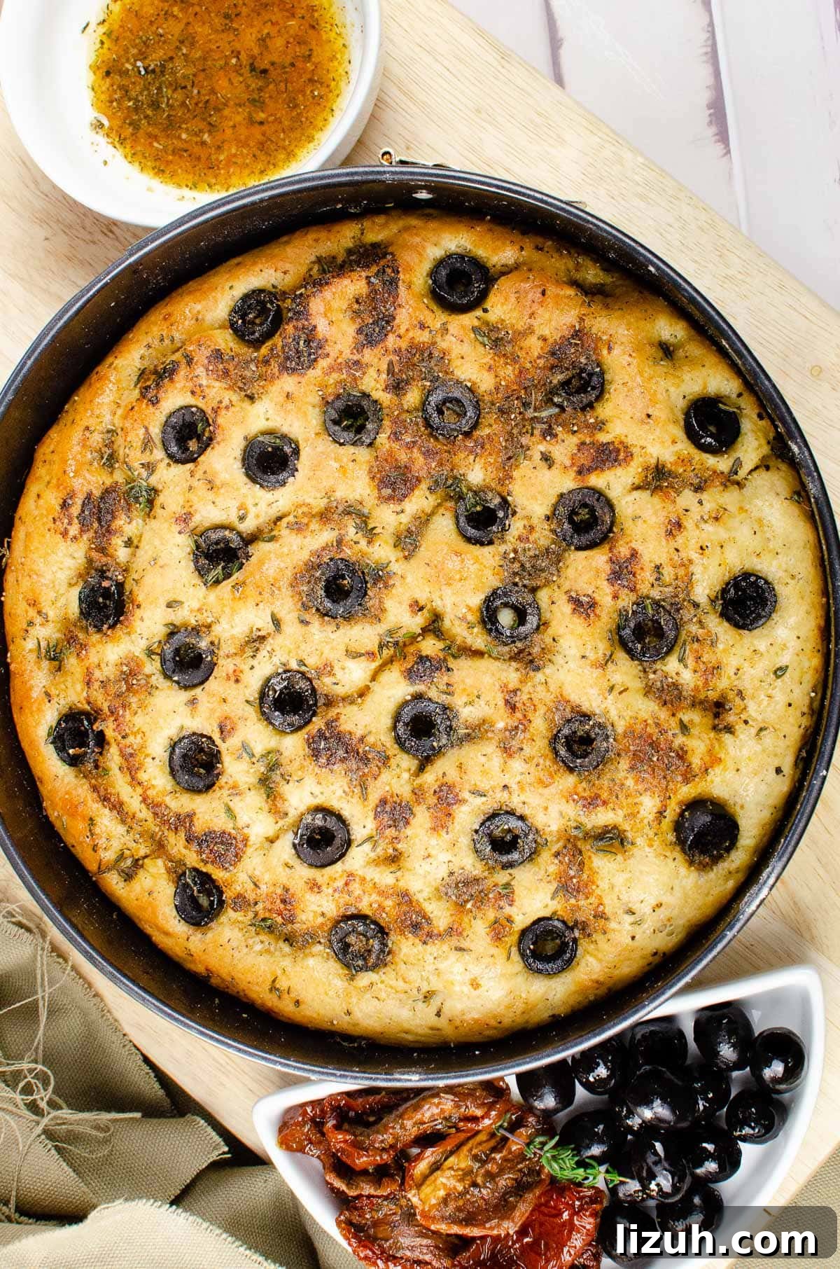 Olive and Herb Focaccia Bread Recipe: Crispy, Flavorful Loaf 2 Cooked focaccia bread in a bread tin on a wooden chopping