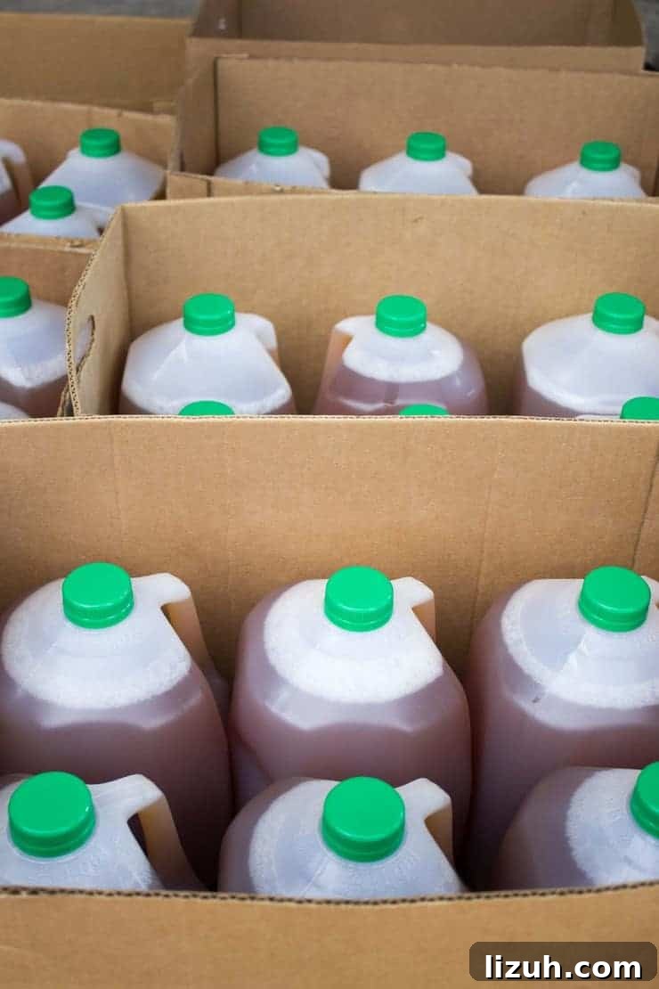 Cider in gallon jugs stacked in boxes. 