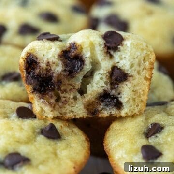 close-up of bite taken out of mini chocolate chip muffin stacked on others