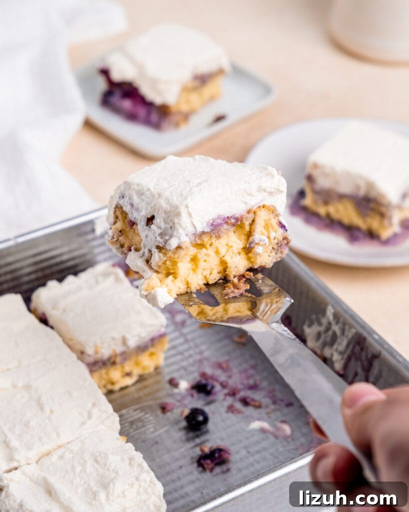Lifting a slice of cake out of the 8x8 inch cake pan with a serving spatula