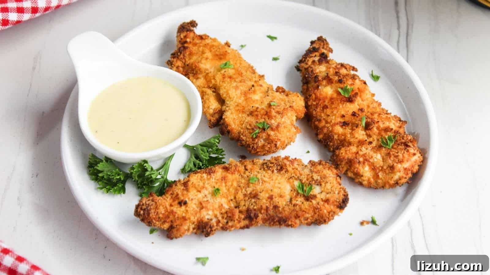Fried chicken tenders on a plate with dipping sauce.