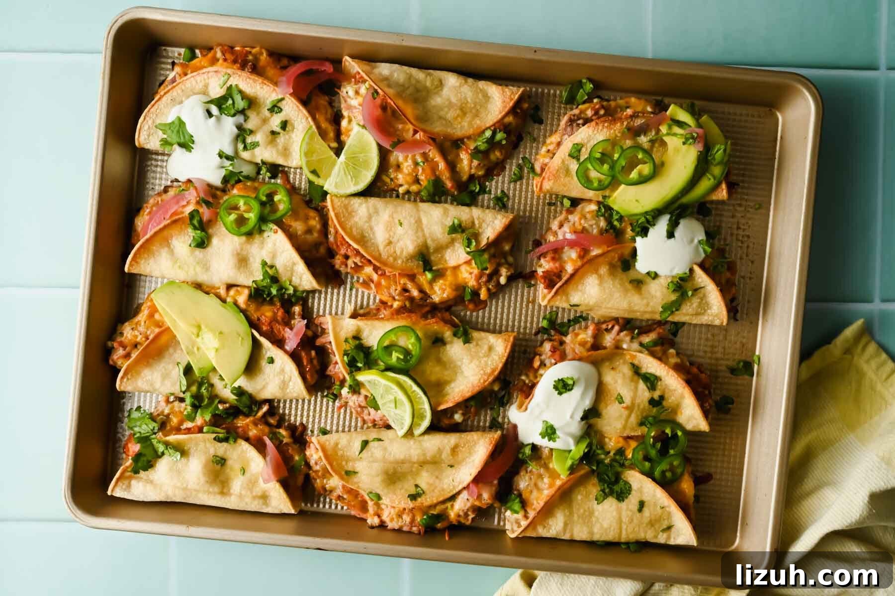 Slow-Cooked Shredded Pork Tacos with Tangy Salsa 2 baked crispy pork tacos topped with herbs, lime wedges, avocado and sour cream.