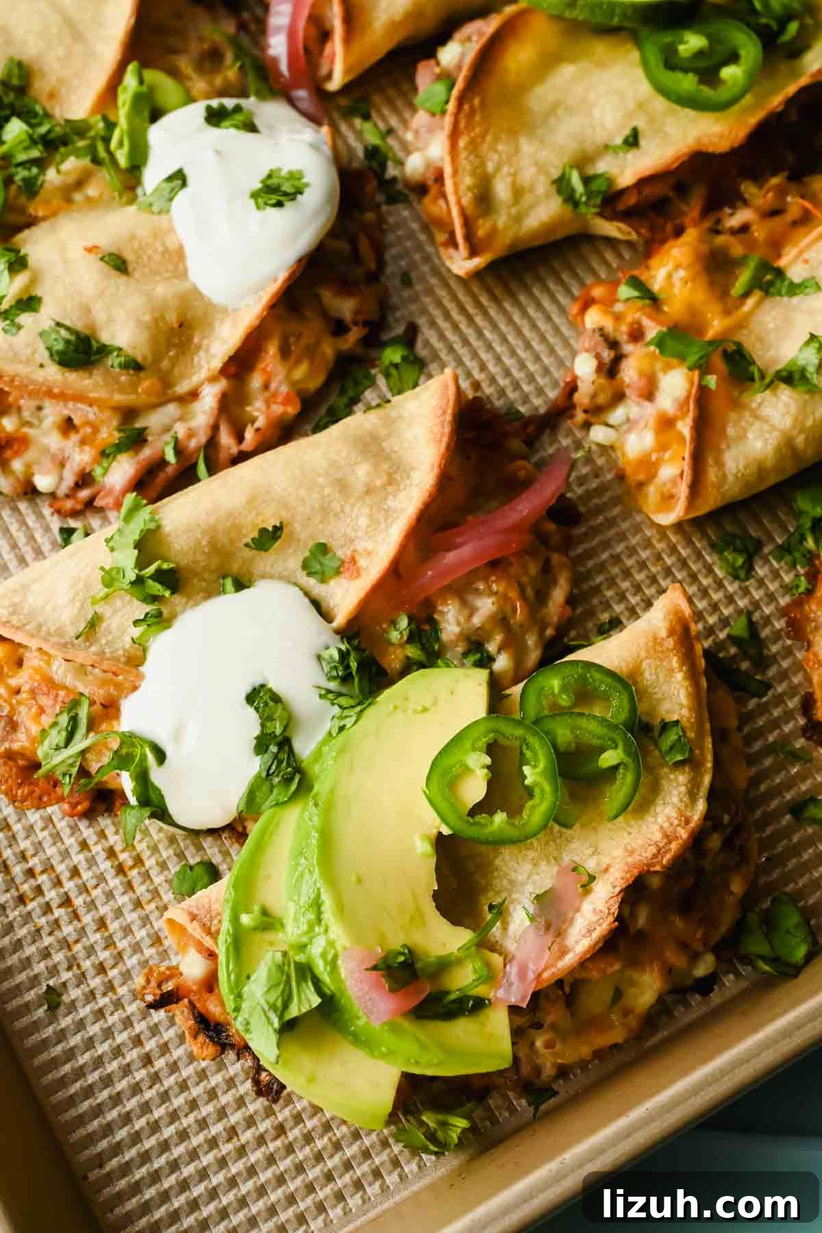 Slow-Cooked Shredded Pork Tacos with Tangy Salsa 5 baked crispy pork tacos topped with herbs, lime wedges, avocado and sour cream.