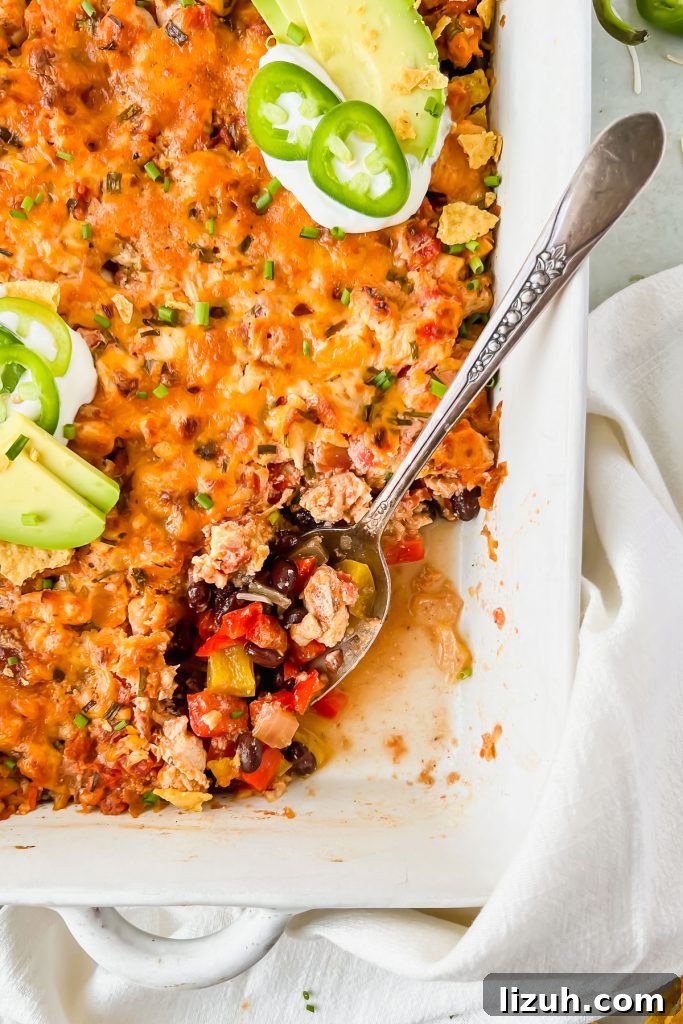 Slow-Cooked Shredded Pork Tacos with Tangy Salsa 9 baked chicken taco casserole garnished with sour cream, jalapeño slices, and avocado slices.