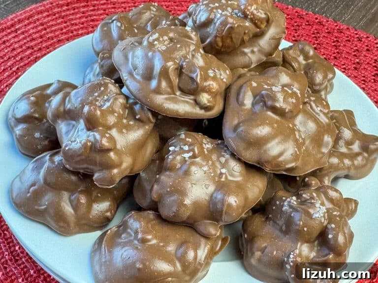 Stack of delicious chocolate covered cashew clusters on a red sparkly placemat.