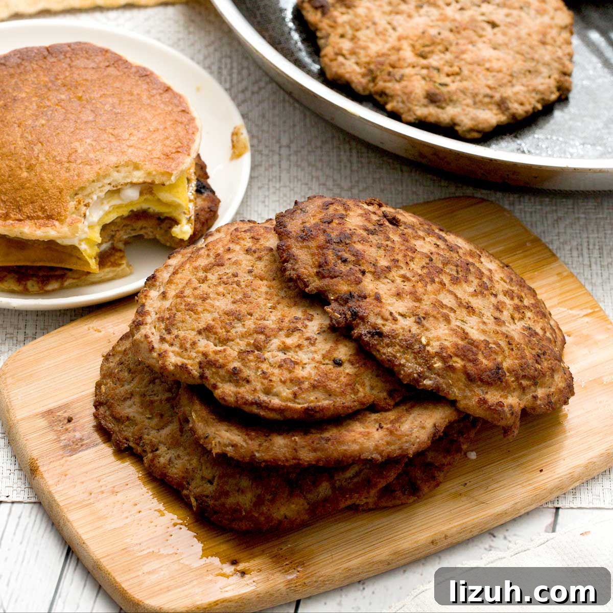 A stack of turkey breakfast patties on a board with maple sausage seasoning.