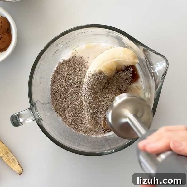 Adding the wet ingredients to a mixing bowl for the baked oatmeal batter.