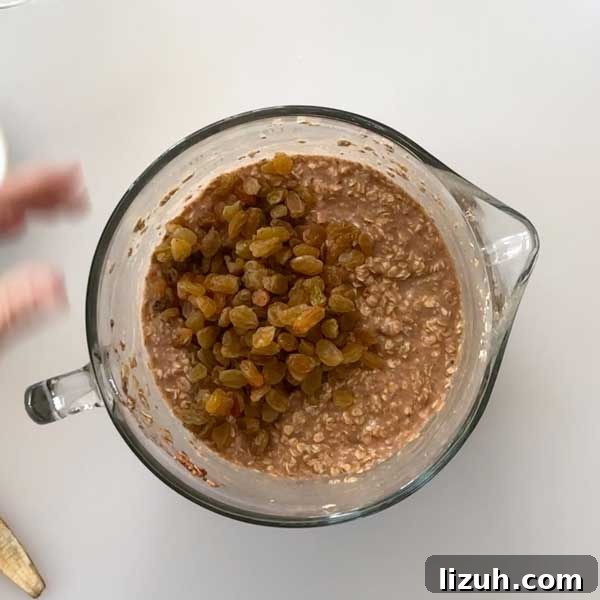 Folding the raisins in with the oatmeal batter.