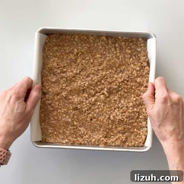 Pouring the baked oatmeal batter into the prepared pan