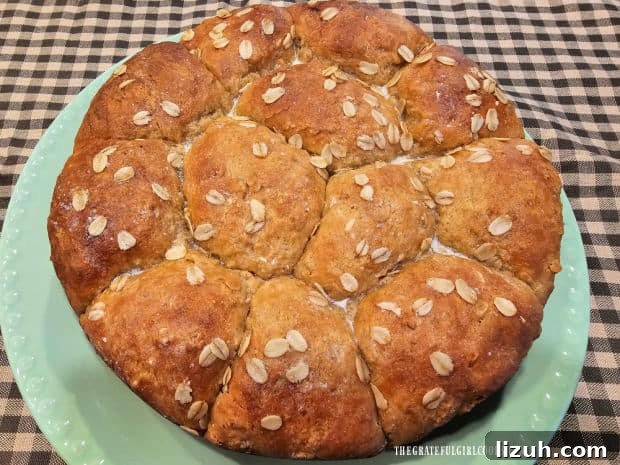 Oatmeal Molasses Dinner Rolls - The Grateful Girl Cooks! A green plate holds the dozen oatmeal molasses dinner rolls, ready to be served.