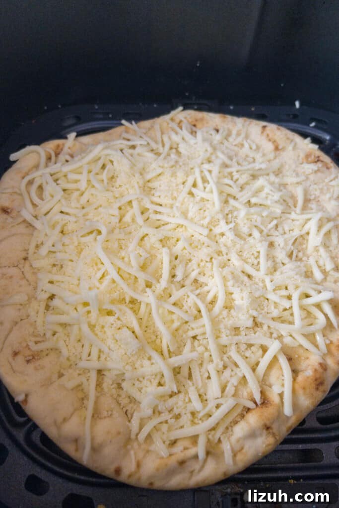 Naan Pizza with Caramelized Onions — Air Fryer or Oven Recipe 4 naan pizza preparation cover in cheese step 1