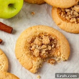 Apple Pie Cookie Recipe: Crispy Cinnamon Apple Jam Cookies 7 A single apple pie cookie with a bite revealing its chewy brown sugar dough and apple filling.