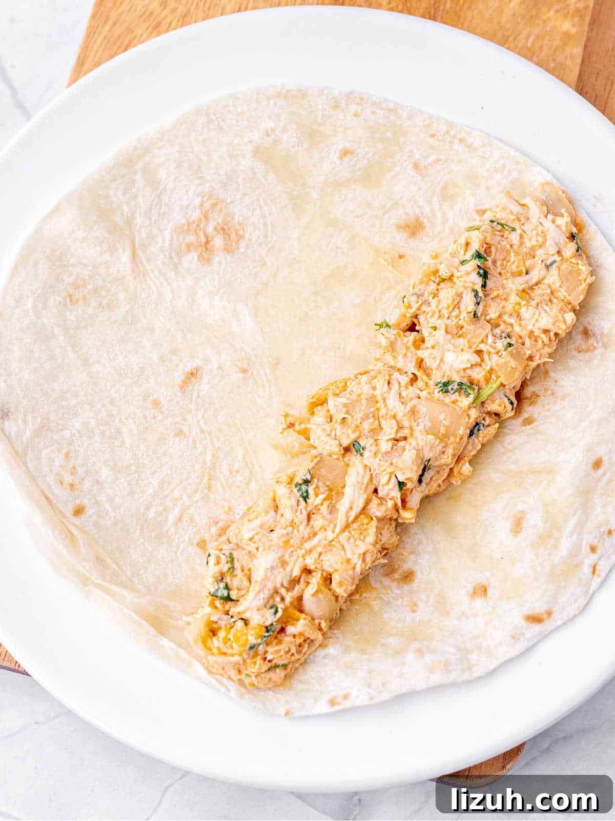 Crispy Baked Chicken Taquitos Recipe for a Flavorful Dinner 5 Tortilla with chicken filling on a white plate.