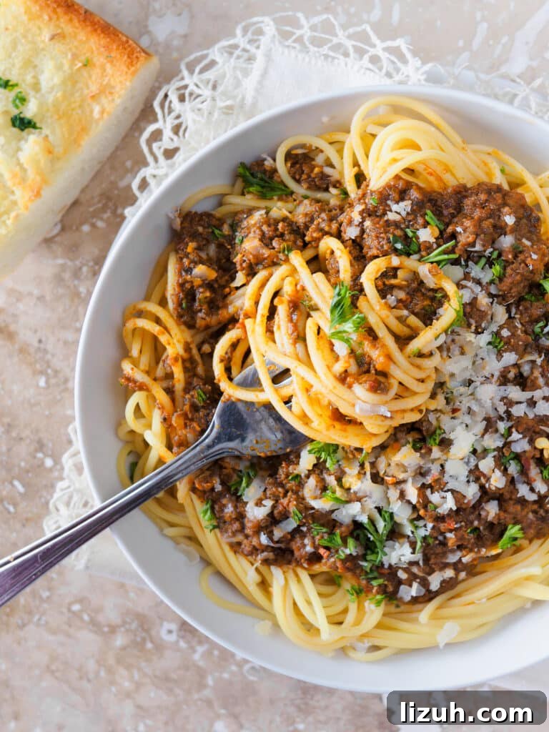 Classic Spaghetti with Savory Meat Sauce Recipe 4 Bowl of spaghetti topped with meat sauce.