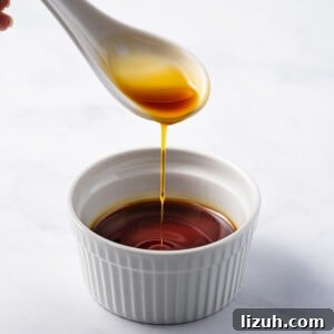 spoonful of Vietnamese caramel sauce (Nuoc Mau) pouring into bowl.