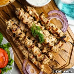 Authentic Greek Chicken Souvlaki Recipe with Tzatziki and Pita 7 Top view of chicken souvlaki on a wood cutting board.