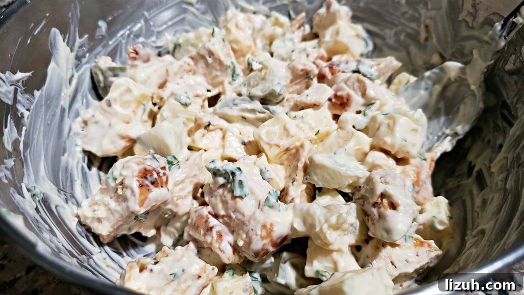Dill Pickle Chicken Salad Sandwich with Swiss Cheese 7 swiss cheese and dill pickle chicken salad mixed together in a bowl.