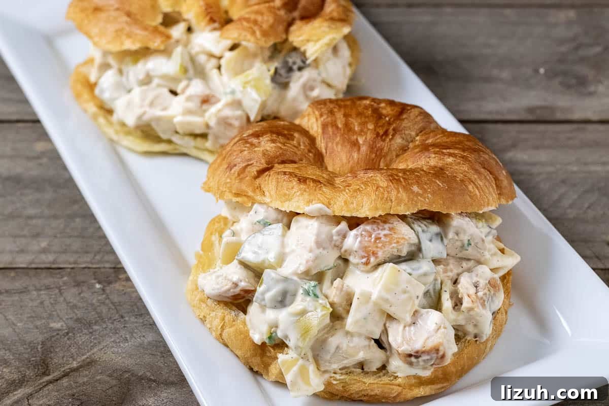 Dill Pickle Chicken Salad Sandwich with Swiss Cheese 8 two swiss cheese and dill pickle chicken salad croissant sandwiches on a platter.
