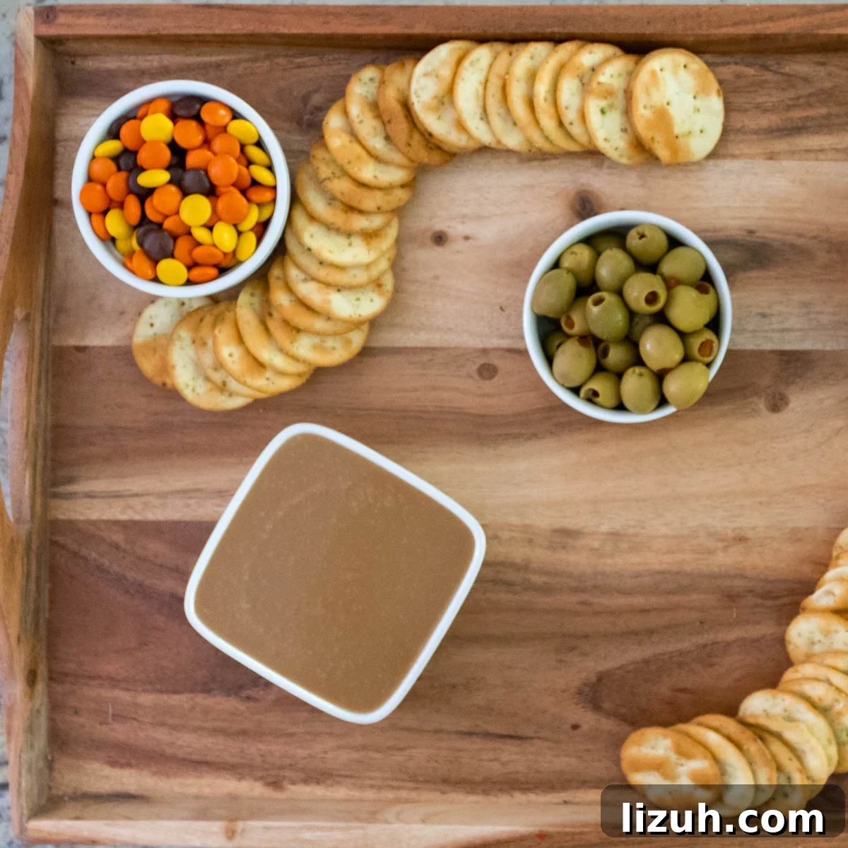 Reese's pieces and crackers on a snack board.