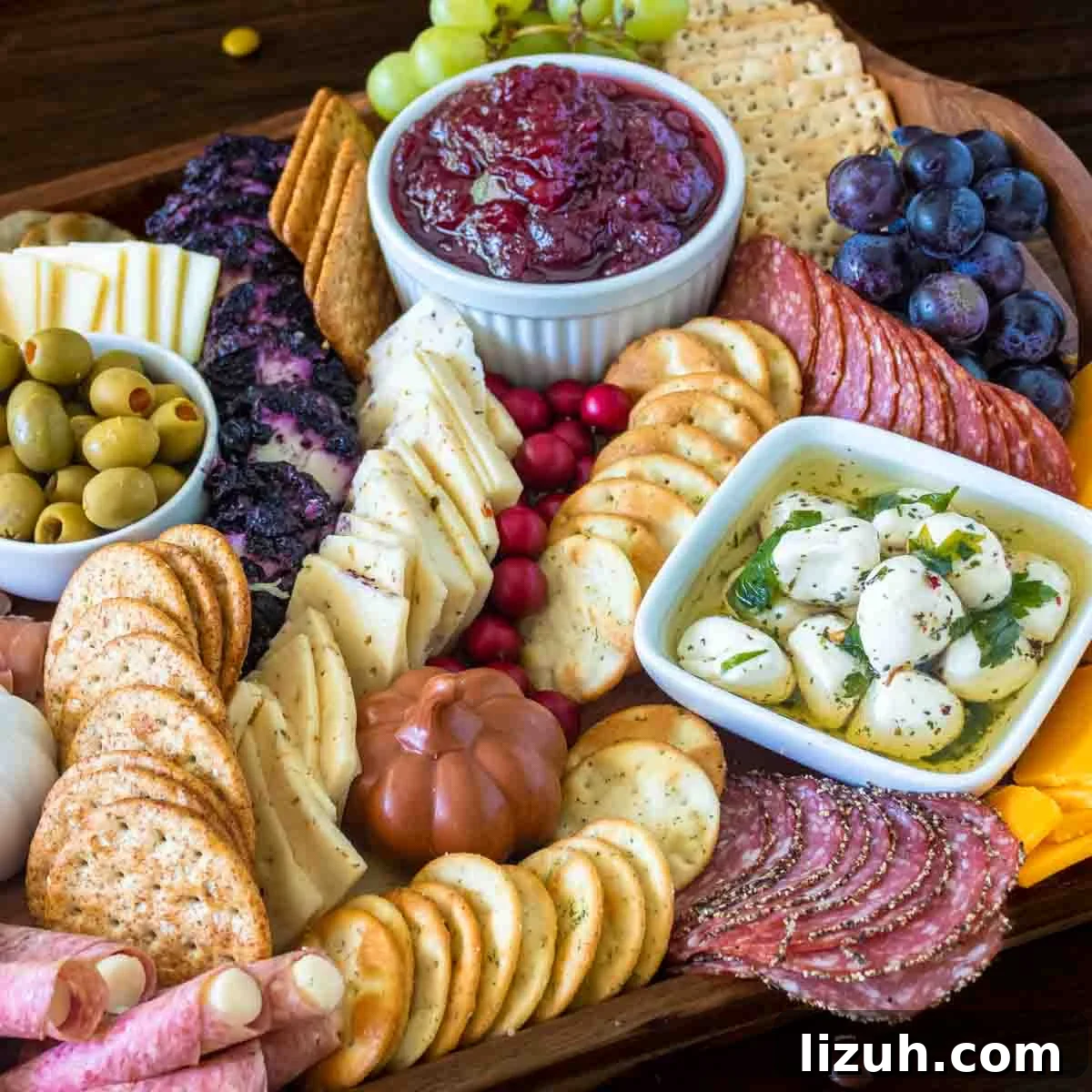 Cranberries, cheese meat and crackers on a thanksgiving charcuterie board.