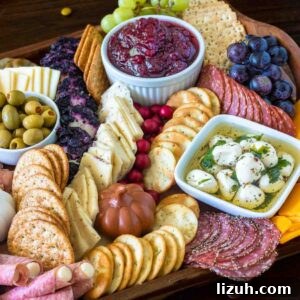 cranberries, cheese meat and crackers on a thanksgiving charcuterie board.