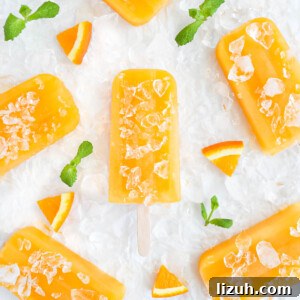 Homemade Orange Popsicles: Refreshing Citrus Ice Pops Recipe 8 Six orange popsicles on ice with orange slices and mint