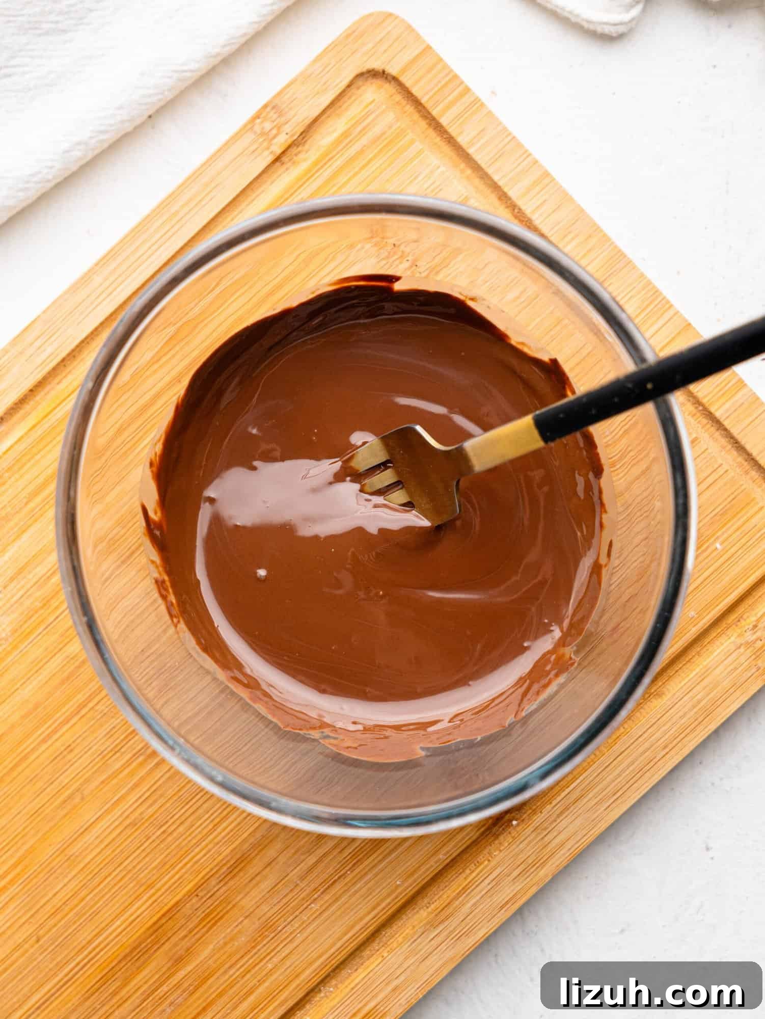 A glass bowl with melted dark chocolate.