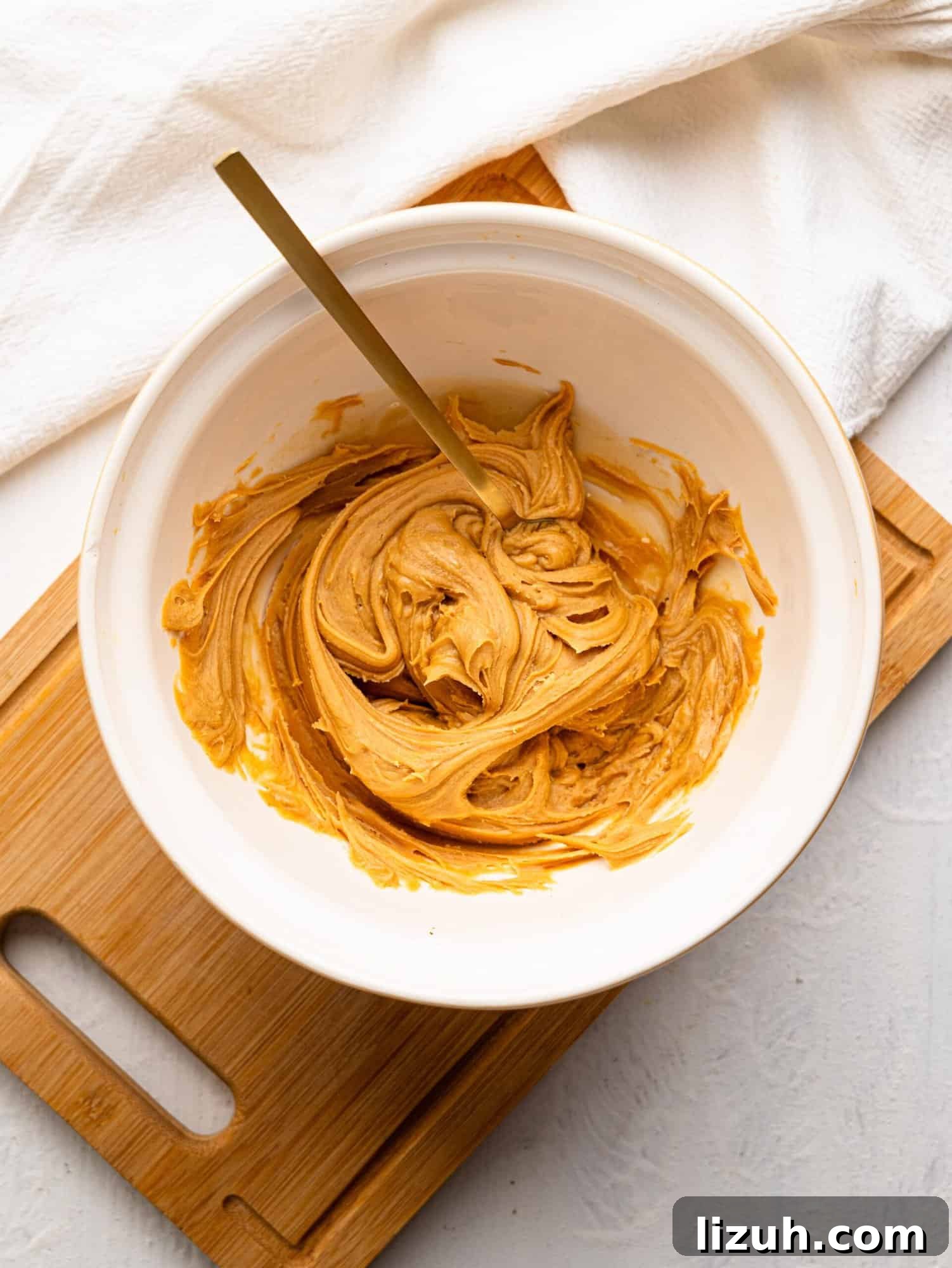 White mixing bowl with peanut butter and honey.