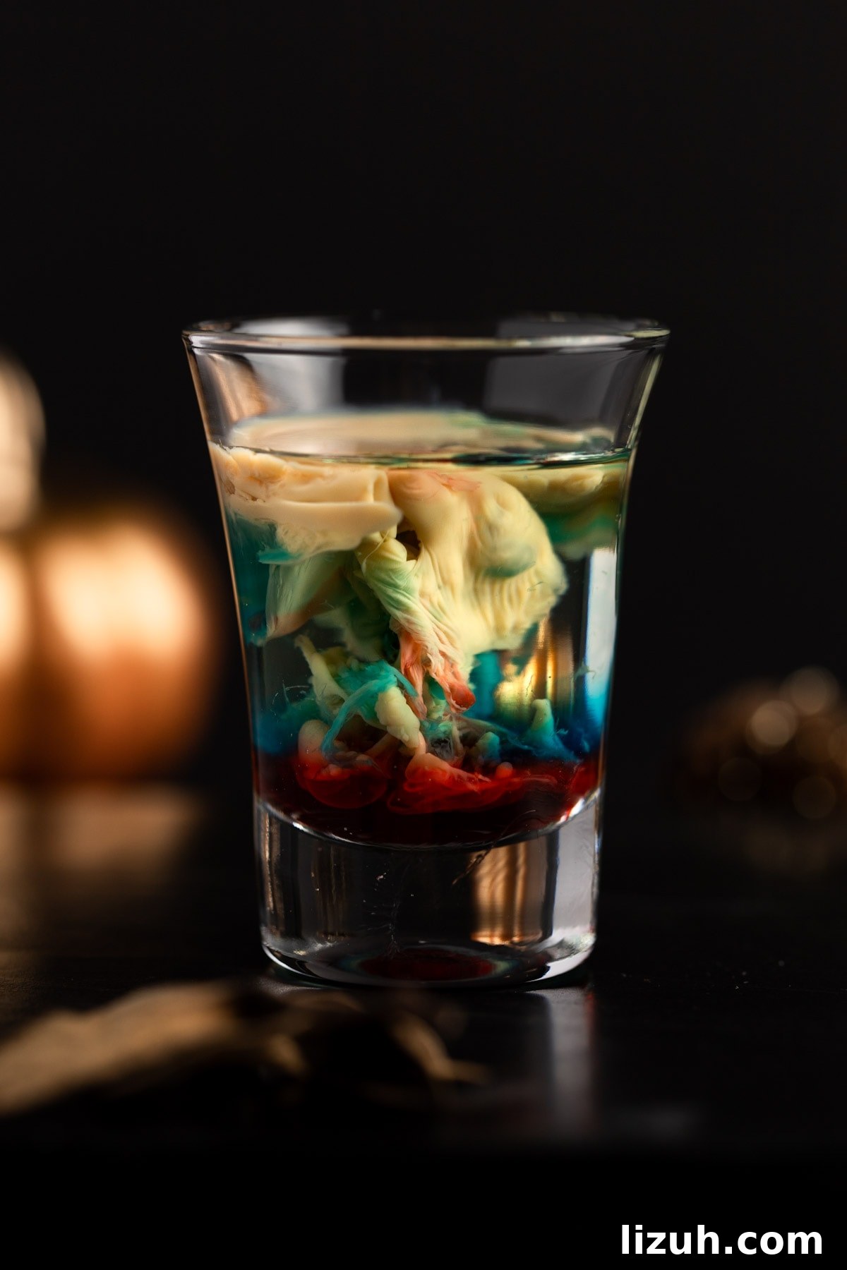 Alien Brain Hemorrhage Shot: How to Make the Viral Party Drink 2 Alien brain hemorrhage shot with mixed red and blue colors, on a black background.