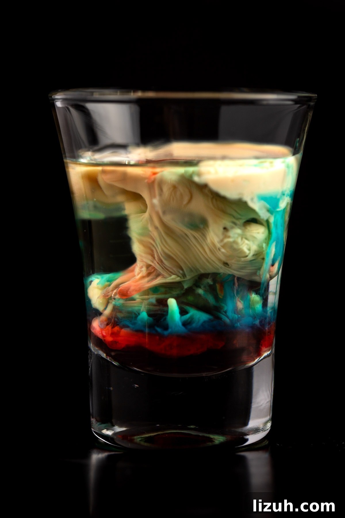 Alien Brain Hemorrhage Shot: How to Make the Viral Party Drink 6 Up close view of the alien brain hemorrhage shot on a black background.
