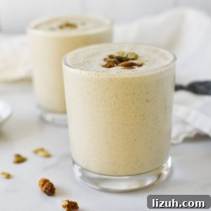 Two pumpkin seed smoothies topped with toasted pumpkin seeds and mulberries