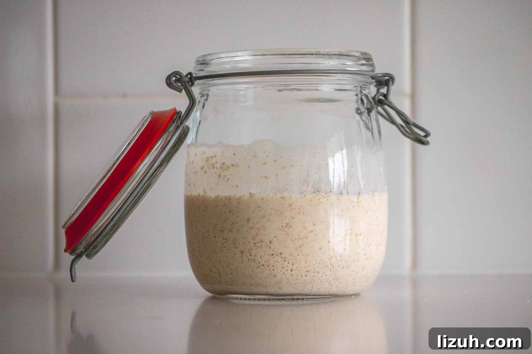 Make a Poolish Starter for Perfect Bread and Pizza Dough 8 A jar with overproofed poolish starter, showing a big rim on the sides of the glass.