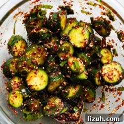Korean Oi Muchim: Spicy Sesame Marinated Cucumber Salad 6 Chopped cucumbers marinated with Korean spices and sesame seeds in a bowl.