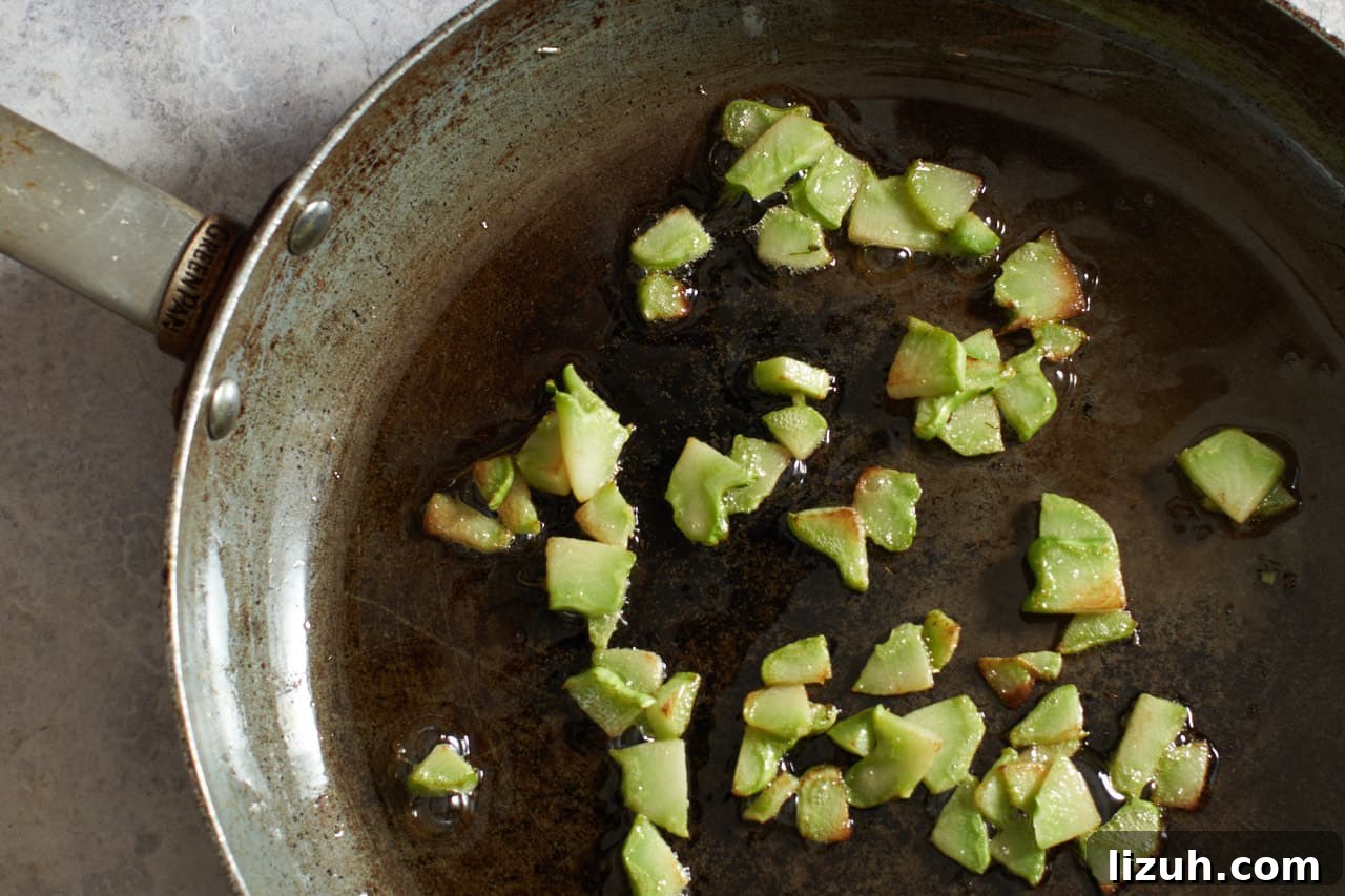 Broccoli stalks browning in a skillet.