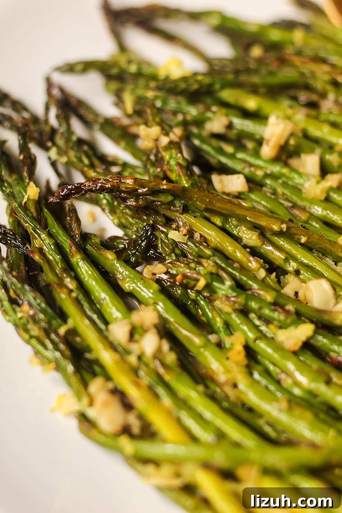 honey lemon butter roasted asparagus on a white plate
