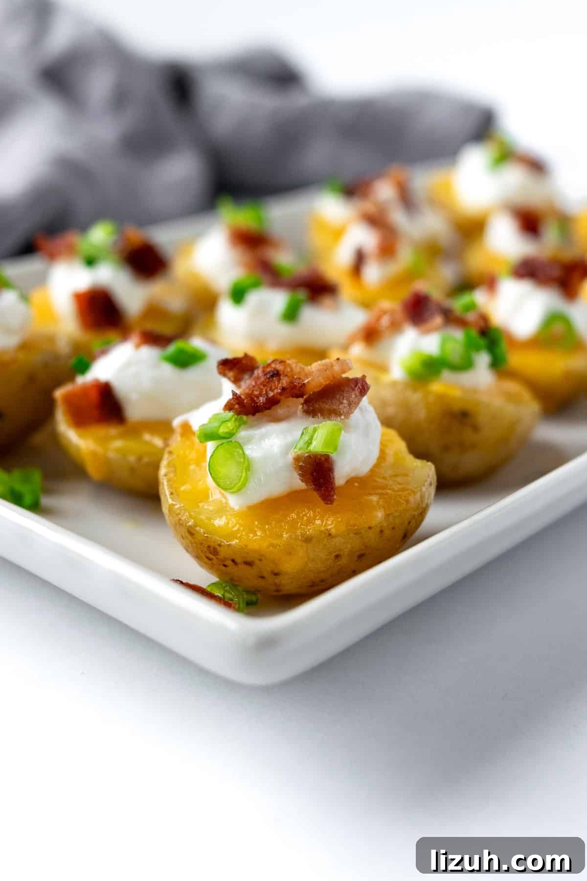 Crispy Baked Potato Bites with Garlic Herb Dip 8 Potato Bites on a white serving plate.