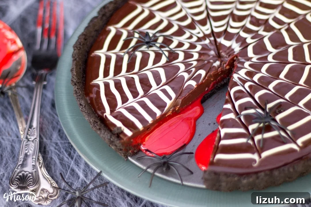 Halloween Chocolate Tart with Bloody Spiderweb Decoration 12 Halloween Dessert | No Bake Bloody Spider Web Chocolate Tart on a plate with plastic spiders