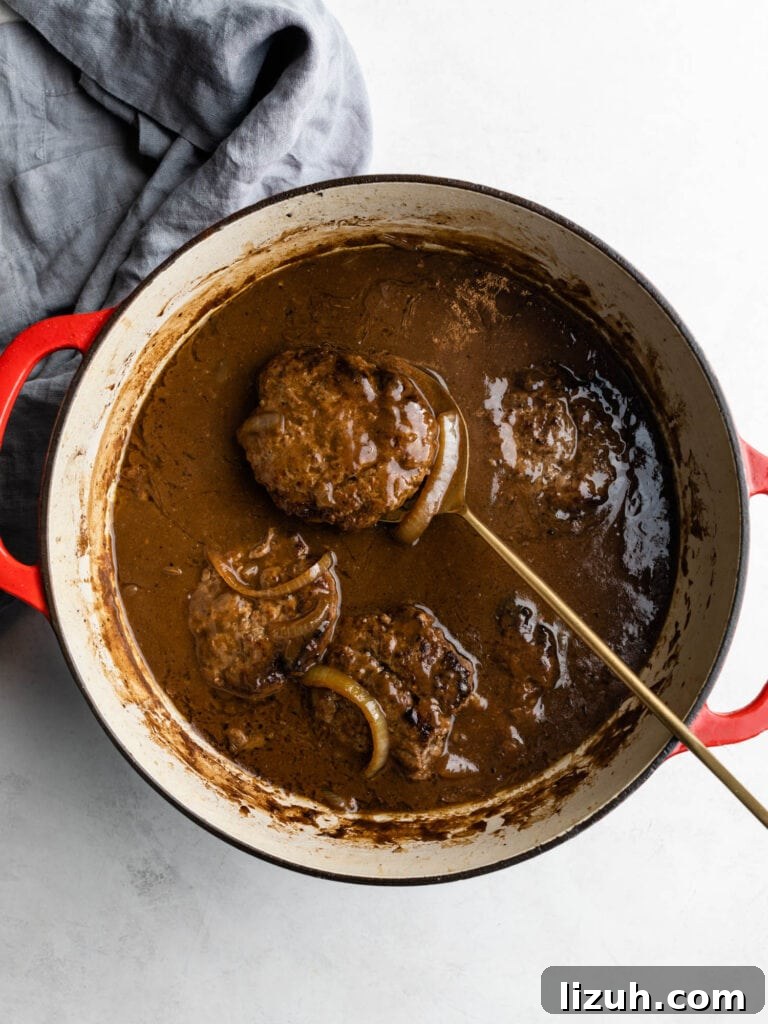 hamburger steaks with onion gravy in a dutch oven