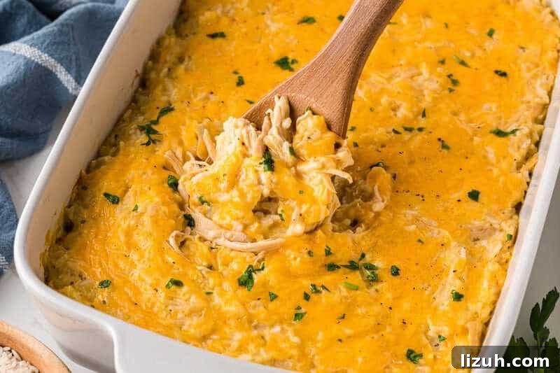 Chicken and Rice Casserole being served with a wooden spoon.