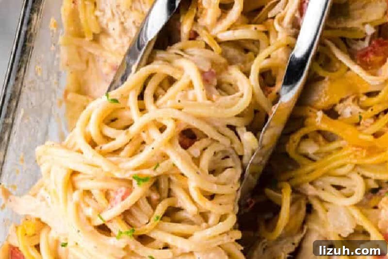 Chicken Spaghetti Casserole being served with tongs.