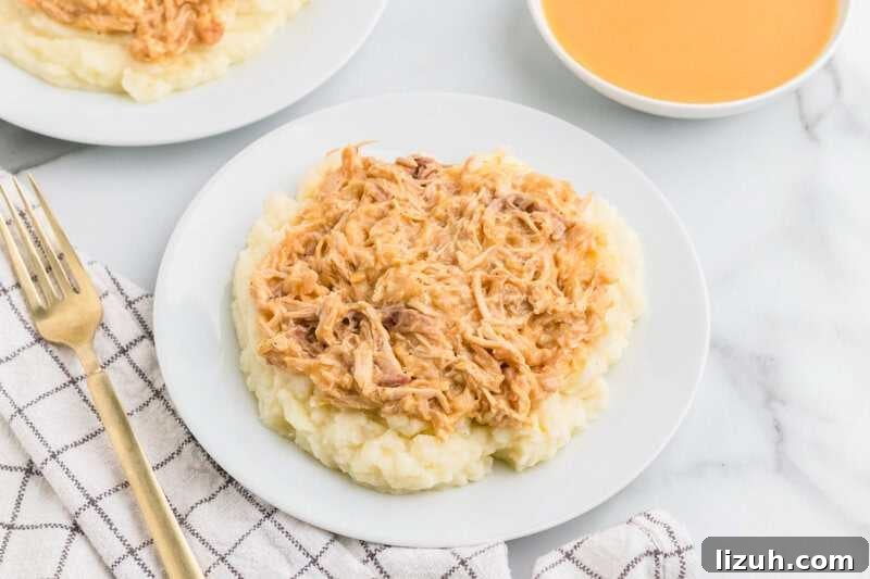 Slow Cooker Chicken and Gravy served on a white plate.