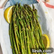 This is a square picture of a plate filled with lemon garlic asparagus.