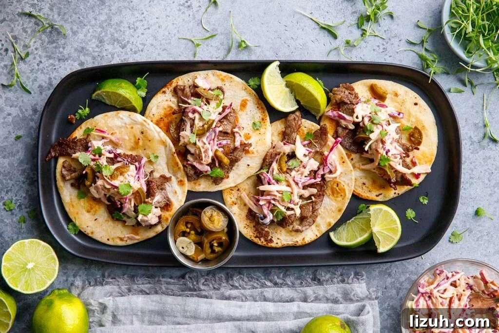 27 Delicious Taco Recipes for Any Night of the Week 8 A plate of street tacos with limes and jalapenos.
