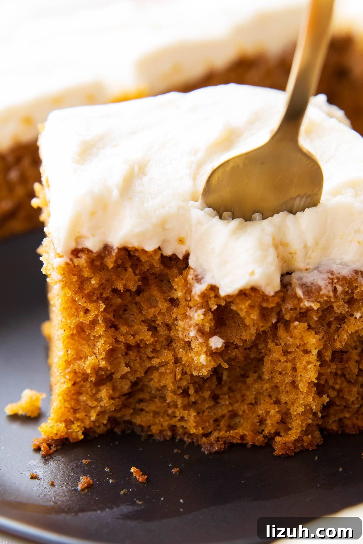 Close up of a fork digging into a slice of this pumpkin cake recipe