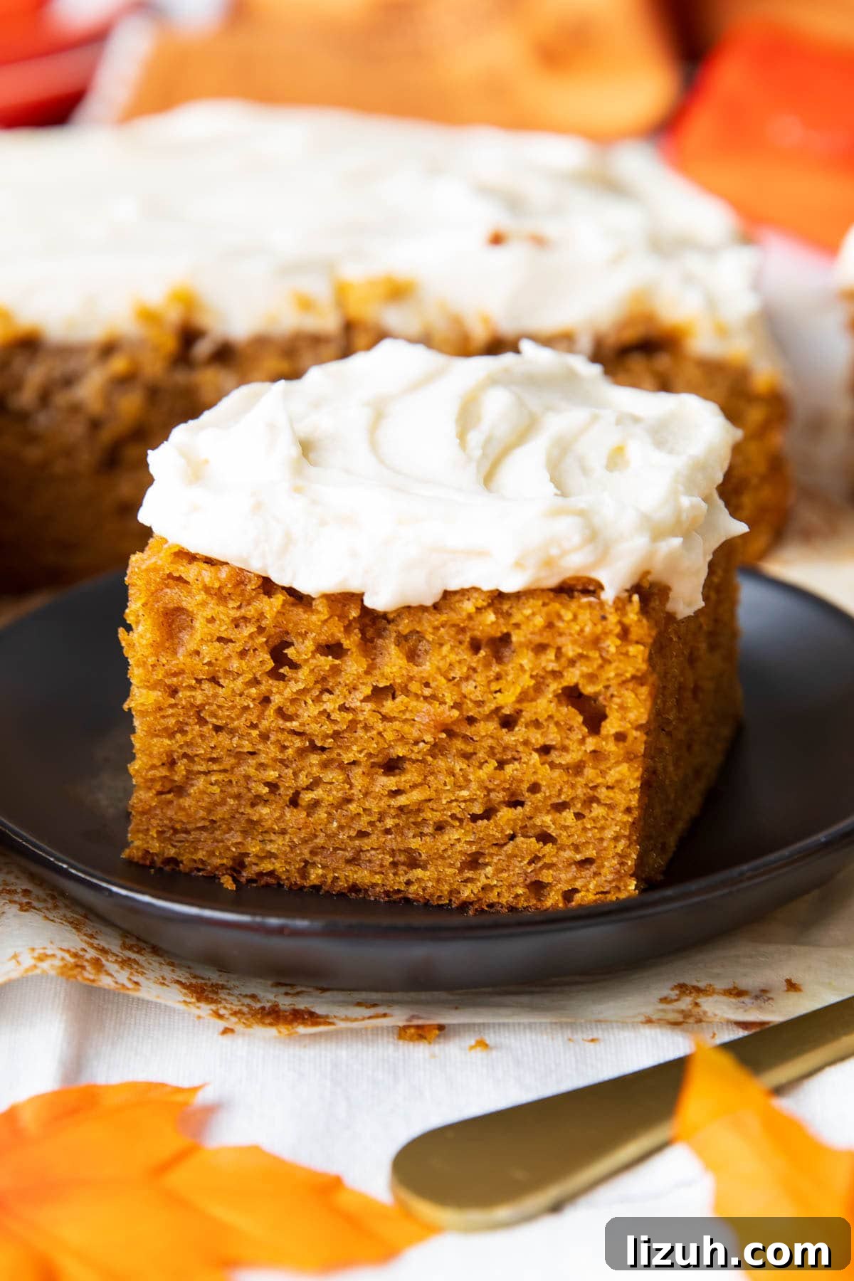 A slice of pumpkin cake with cream cheese frosting that’s moist with a tender crumb